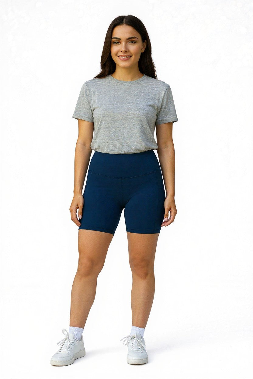Woman wearing a gray t-shirt and navy blue shorts on a white background