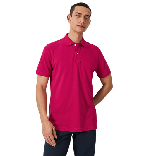 A man wearing a pink premium pique polo shirt with a classic collar and a two-button placket.
