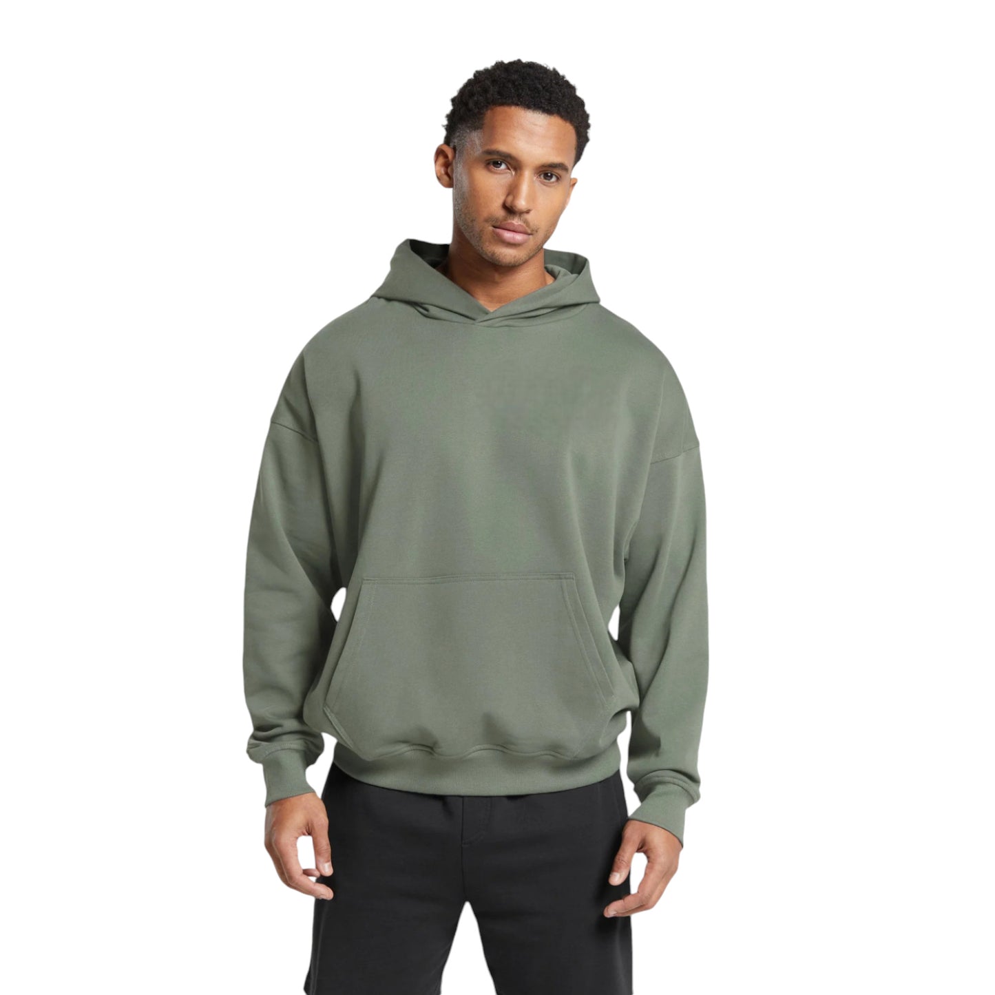 A male model wearing an oversized sage green hoodie with a hood, front kangaroo pocket, and ribbed bottom hem.