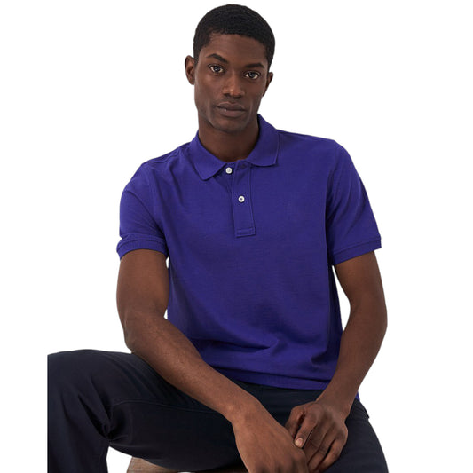 A man wearing a blue premium soft touch polo shirt with a classic collar and a two-button placket.