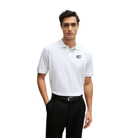 A man wearing a white short-sleeve polo shirt with a collar, button placket, and a logo on the chest.