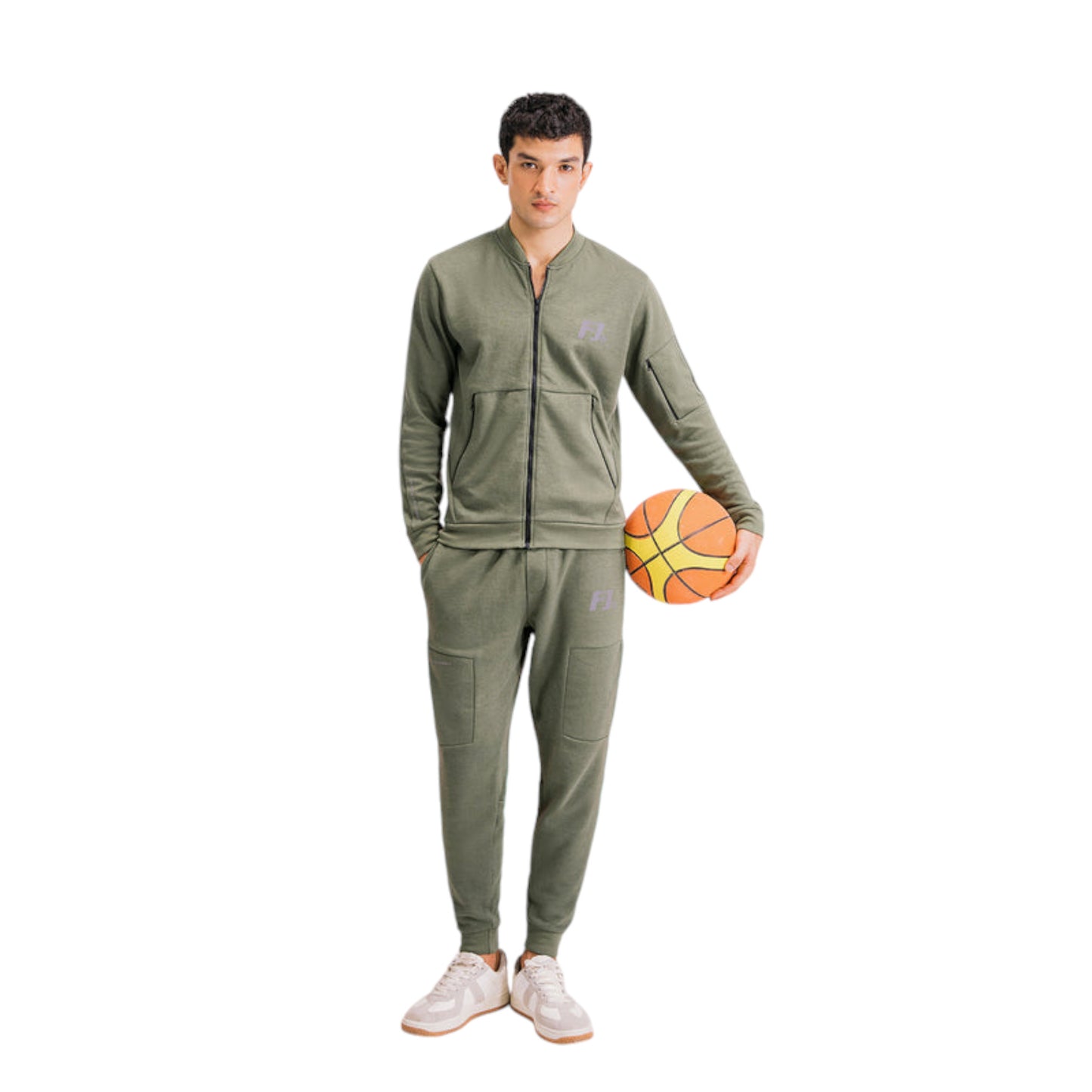 A male model wearing a green full-zip tracksuit holding a basketball.