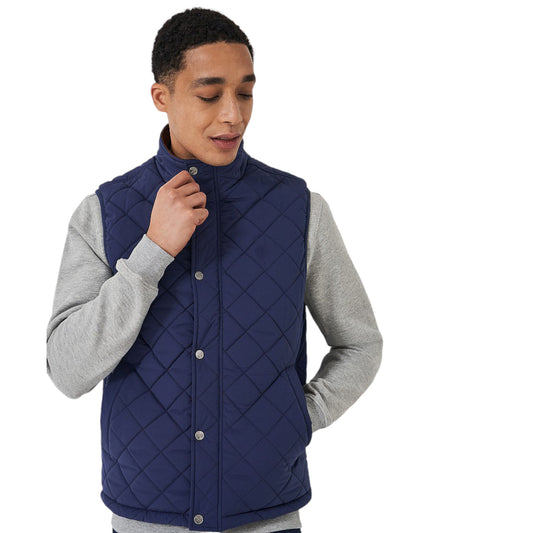 A man wearing a navy blue quilted puffer vest with a zipper front, over a grey sweater.