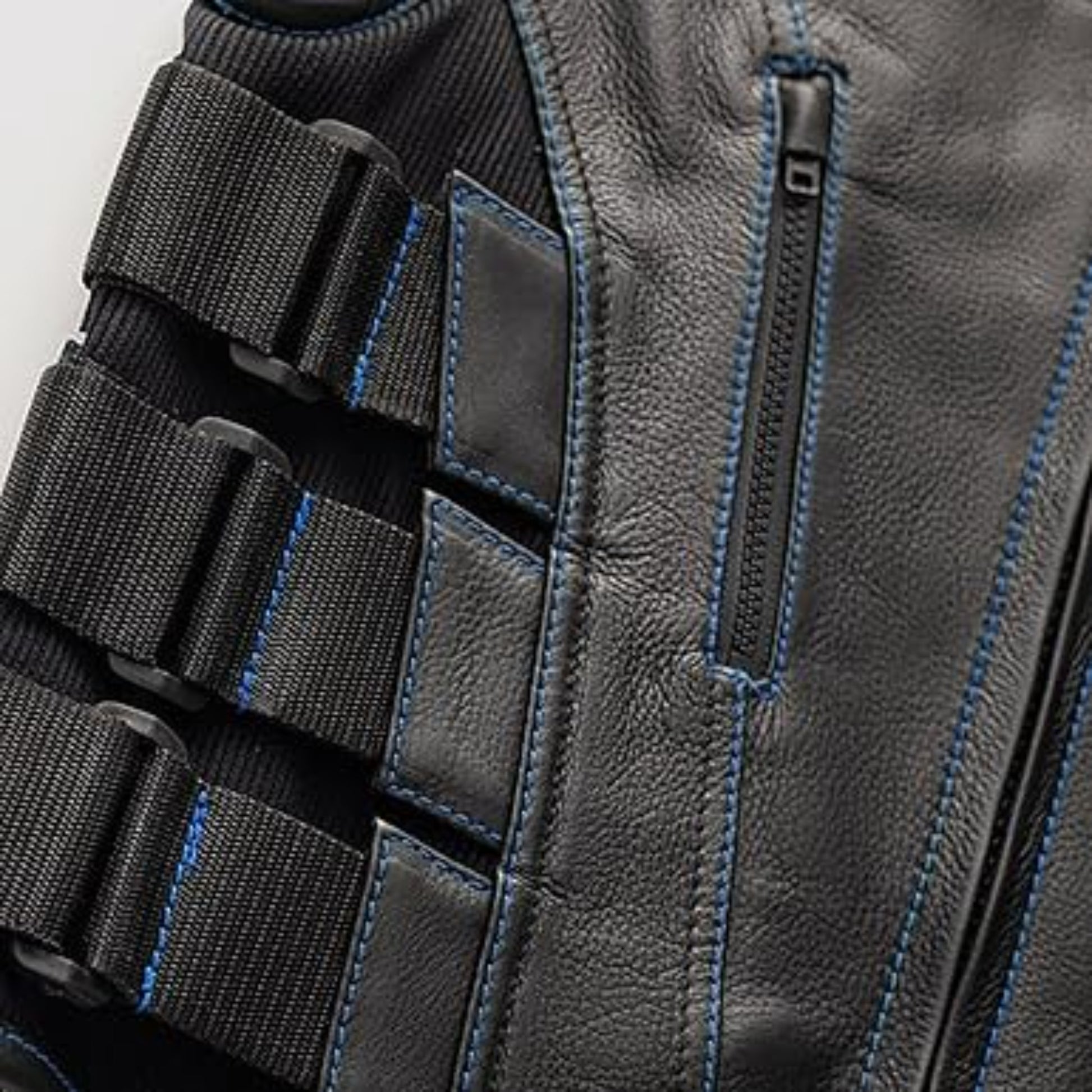 Close-up of a gray tactical vest with black straps and blue stitching on a white background