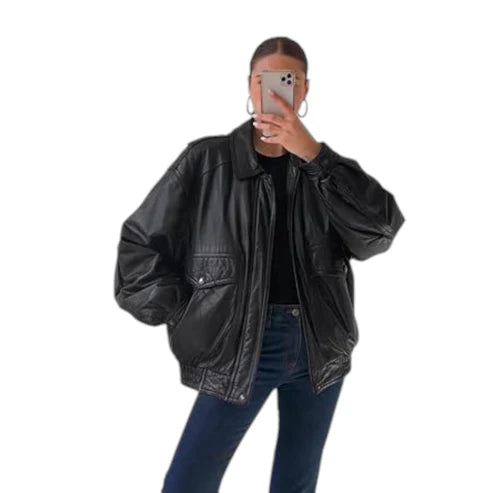 Person wearing a black leather jacket and blue jeans on a white background