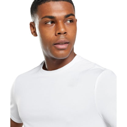Man wearing a plain white t-shirt against a white background