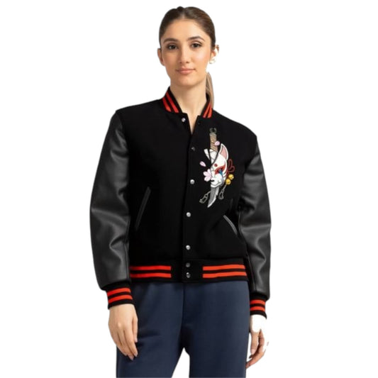 Woman wearing a black varsity jacket with red accents on a white background
