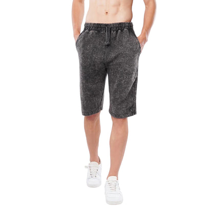 A pair of athletic shorts with an elastic waistband, depicted in a grayish color, modeled by a male without a shirt.