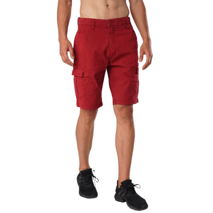 A model wearing vibrant red scarlet cargo shorts with functional pockets and an elastic waistband, paired with a black top and black sneakers.