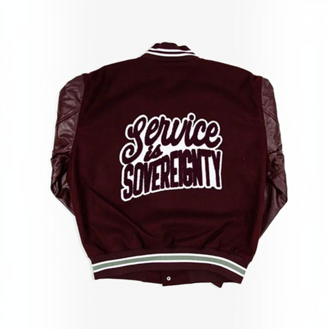 A maroon varsity-style jacket shown from the back, featuring dark brown leather-look sleeves and a large white embroidered graphic reading 'Service is SOVEREIGNTY' across the back. The jacket has white and light green striped ribbing at the collar, cuffs, and hem.