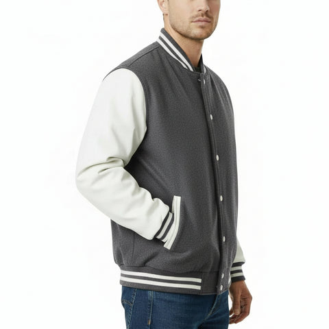 Man wearing a Dark Grey and white varsity jacket on a white background