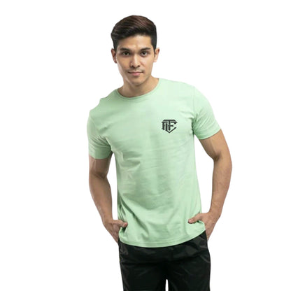 A man wearing a green, short-sleeved, crew neck t-shirt with a logo on the chest.