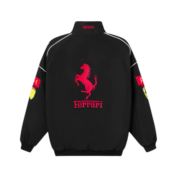 A black Ferrari jacket shown from the back, featuring a large red prancing horse logo and 'Ferrari' text in red on the center back, with white piping details and red/yellow logo patches on the sleeves.