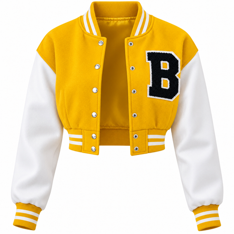 A cropped varsity jacket with a yellow body and white sleeves, featuring a large black letter 'B' patch on the left chest, silver snap buttons, and striped ribbed trim.