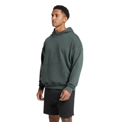 Man wearing a green hoodie and black shorts on a white background