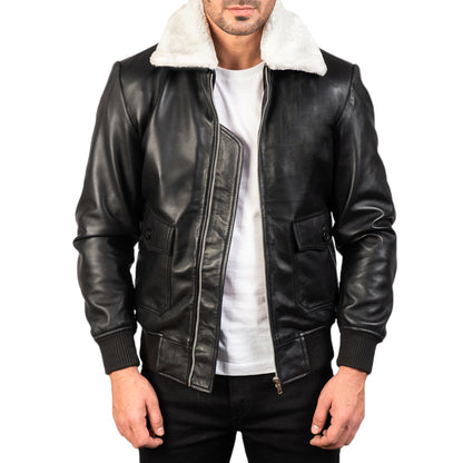 A man wearing a black and white leather bomber jacket with a white crew neck t-shirt and black trousers.