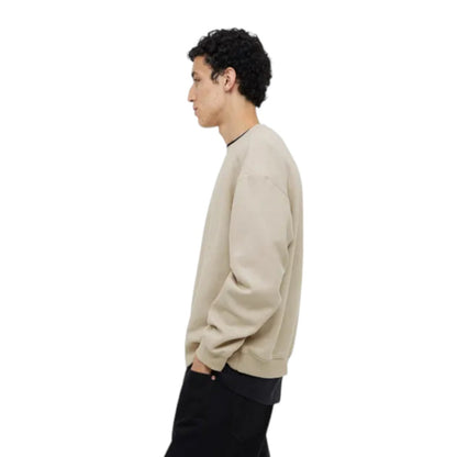 Person wearing a beige sweater on a white background