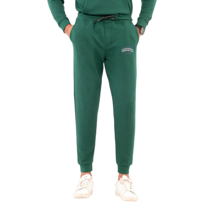 A pair of men's green jogger pants with a drawstring waist, displayed on a model wearing a matching green hoodie and white sneakers.