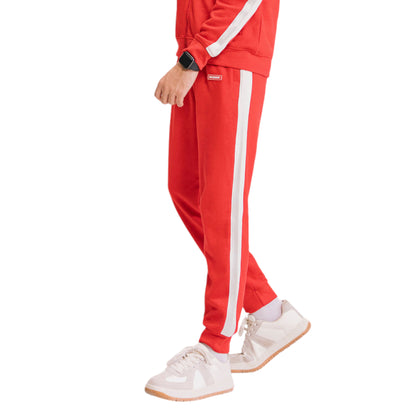 A person wearing red trousers with a white stripe on the side and white sneakers.