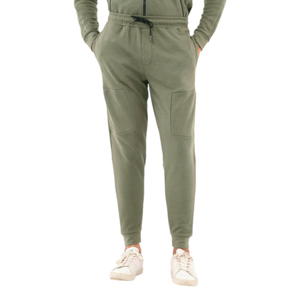 A pair of slim fit trousers in green, with pockets and a mid-rise waistband, worn with white sneakers.