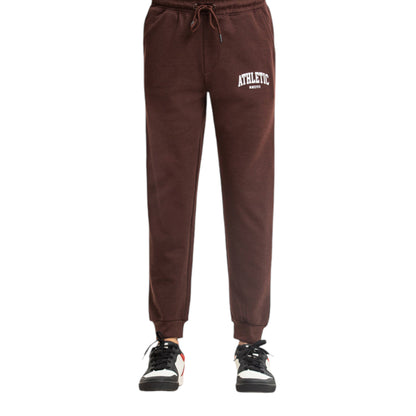 A pair of brown travel trousers with an adjustable waistband, featuring a 'ATLANTIC' brand logo on the upper left, paired with a white and black pair of sneakers.