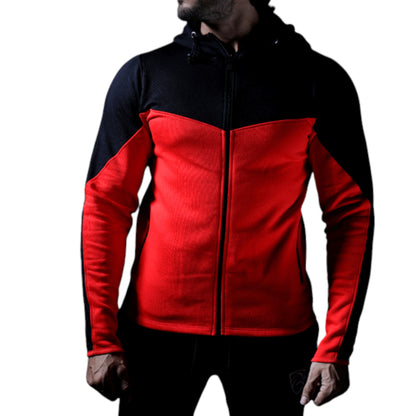 A male model wearing a black and red zippered tracksuit top with long sleeves. The jacket has contrasting colors with a red front and black sides and hood.