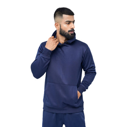 A man wearing a navy blue slim fit track suit jacket with a stand-up collar, full-length front zipper, and ribbed cuffs and hem.