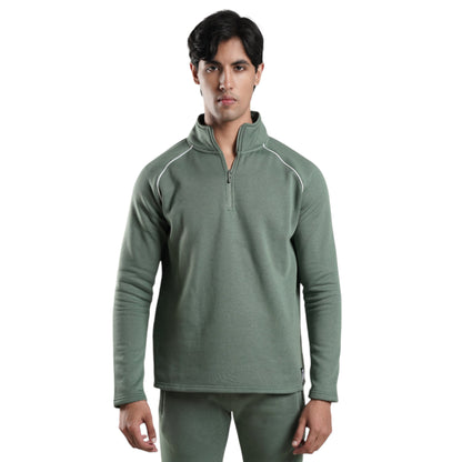 A male model wearing a green relaxed fit track top with a full zipper, long sleeves, and a high collar.