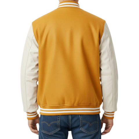 Back view of a person wearing a mustard yellow and white varsity jacket with blue jeans on a white background