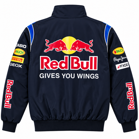 A navy blue Red Bull jacket shown from the back, featuring the large red and yellow Red Bull logo with the slogan 'GIVES YOU WINGS' in white. The sleeves are decorated with various sponsor logos including Red Bull, Casio, Pirelli, and Peugeot.
