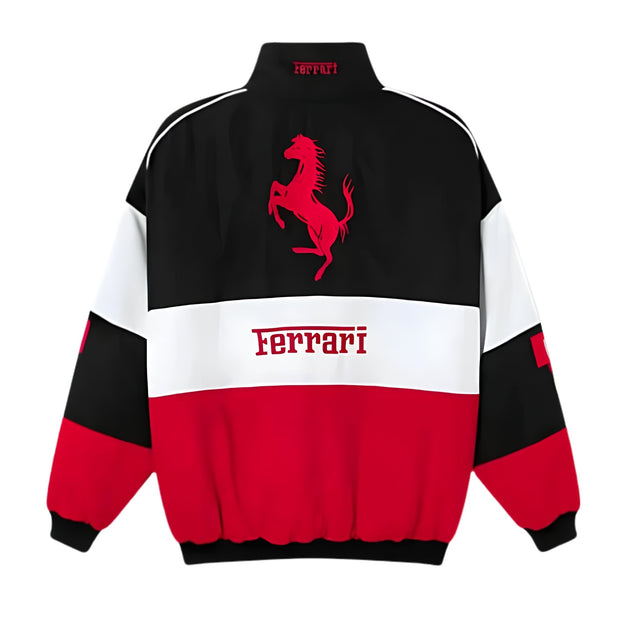 A Ferrari colorblock jacket shown from the back, featuring a black upper section with a red prancing horse logo, a white middle band with 'Ferrari' text, and a red lower section, on a white background.