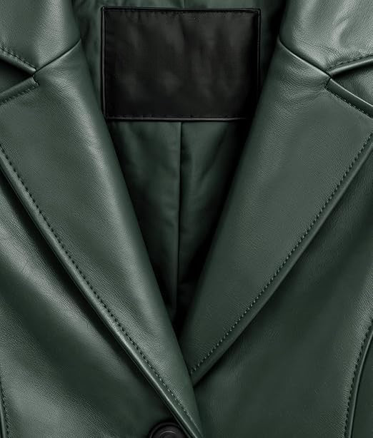 Close-up of a dark forest green leather jacket showing the lapels, fine stitching, and a black interior lining.