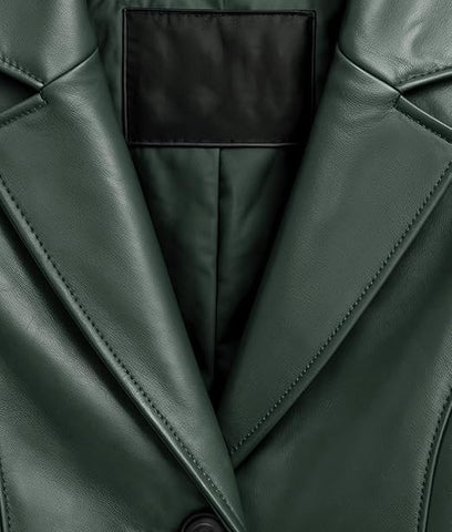 Close-up of a dark forest green leather jacket showing the lapels, fine stitching, and a black interior lining.