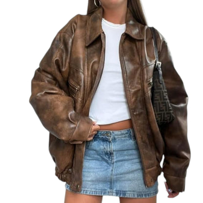 Person wearing a brown leather jacket, white top, and denim skirt on a white background