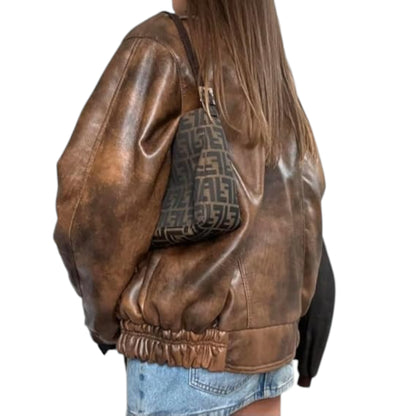 Brown leather jacket worn by a person with a patterned bag.