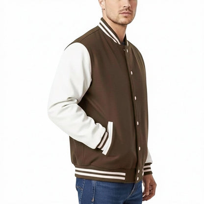 Fit to lead Traders brown varsity jacket with white sleeves, ribbed collar, cuffs, and hem. Unisex streetwear fit.