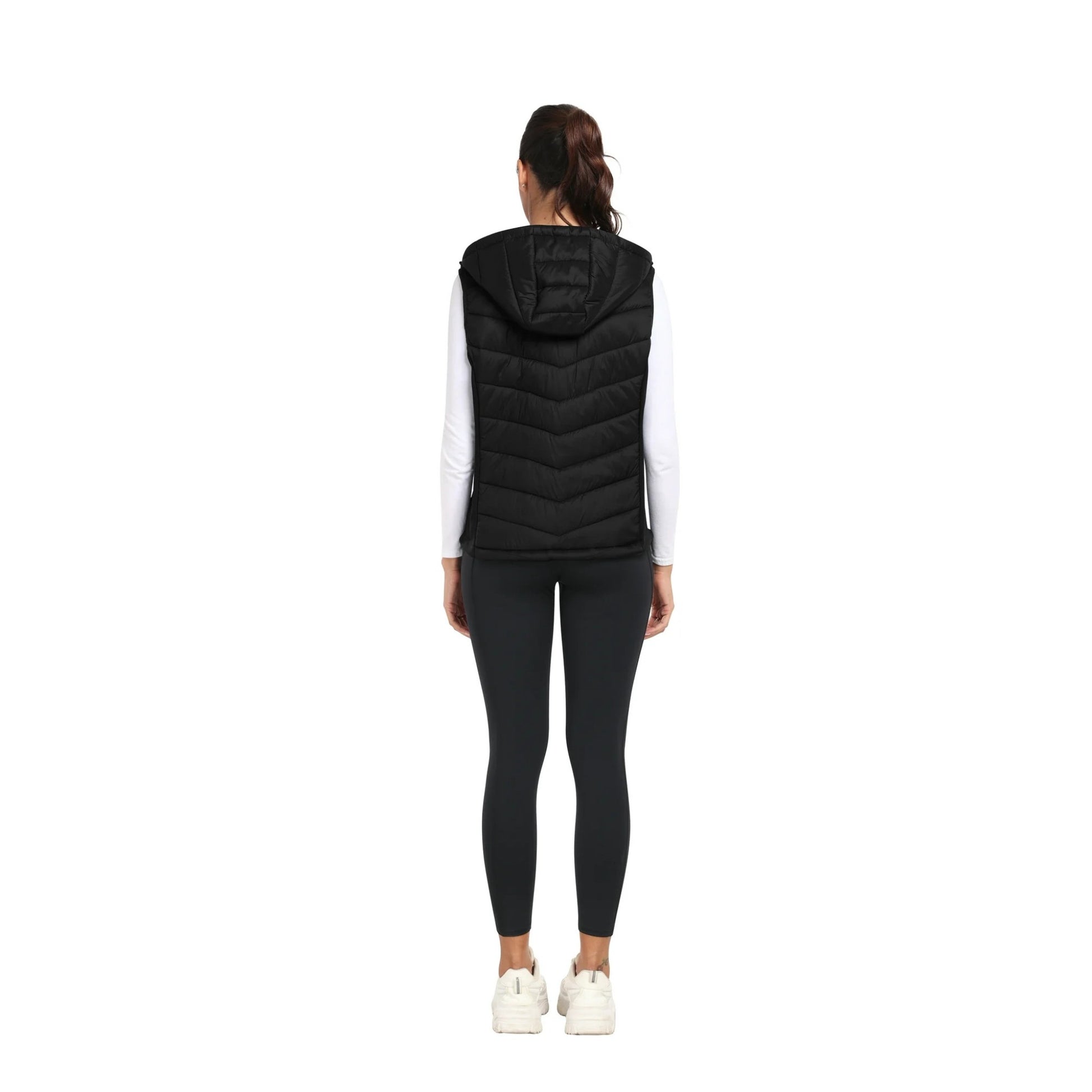 Person wearing a black puffer vest on a white background