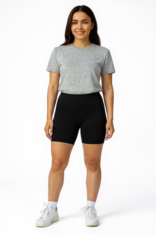 Woman wearing a gray t-shirt and black shorts on a white background